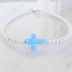 Crosses represent self, nature, faith, wisdom, hole, unity, and love! This beautiful bracelet or necklace is made with a brilliant lab-created opal cross in either white or blue. Choose between 3 finishes: sterling silver, gold filled, or rose gold filled. One inch of extra chain lets you adjust the bracelet to your preference. All items are hand-made in the USA in a smoke-free studio, and most importantly, they're made with OurWholeHeart❤︎ ------------------------------------------------------- Nickel-free Cross Bracelet Gift, Nickel Free Cross Bracelet With Spiritual Style, Nickel-free Cross Bracelet For Spiritual Style, Silver Cross Jewelry For Friendship, Spiritual Cross Bracelets As Gifts, Spiritual Cross Bracelets, Inspirational Hypoallergenic Round Bead Jewelry, Sterling Silver Friendship Spiritual Bracelets, Spiritual Sterling Silver Bracelets