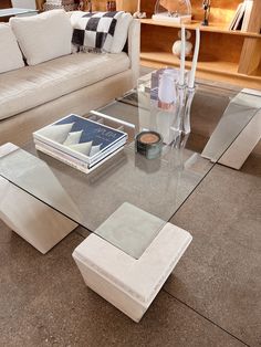 a glass coffee table sitting on top of a living room floor