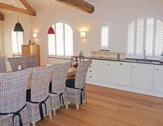 a dining room table with many chairs around it and an oven in the back ground