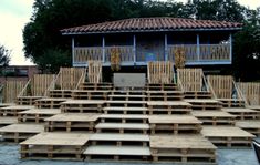 several wooden pallets stacked on top of each other in front of a blue building