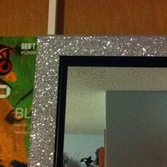 the reflection of a cat in a mirror with silver glitter on it's frame