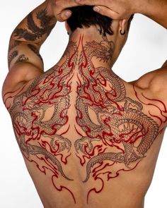 the back of a man with tattoos on his chest and arms is shown in red ink