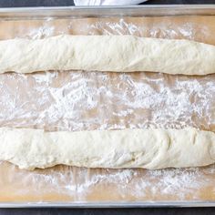 two uncooked doughs sitting on top of a baking sheet