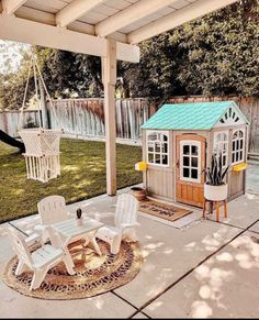 a small wooden house sitting on top of a patio next to a white lawn chair