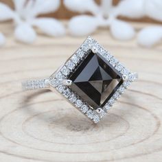 a black and white diamond ring on top of a tree stump