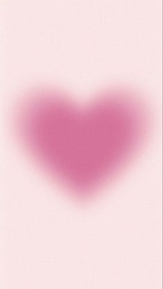 a blurry image of a red heart on a pink background with the word love written below it