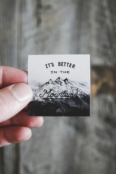 someone holding up a business card that says it's better in the mountains