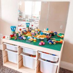 a toy table with legos and toys on it in front of a large mirror