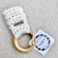 a wooden ring with a white knitted cover on it and a card next to it