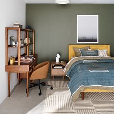 a bed room with a neatly made bed next to a desk and chair in it