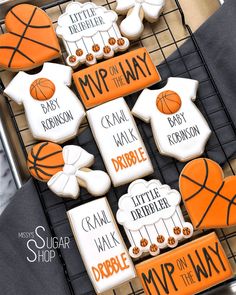 decorated cookies are arranged on a cooling rack with basketballs and words that spell out the names of their favorite sports teams