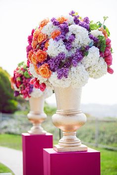 two vases filled with flowers sitting on top of each other