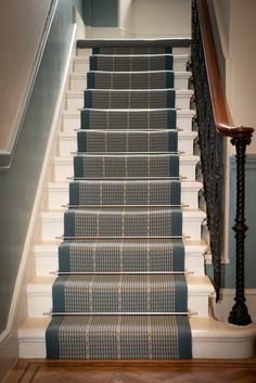 a staircase with blue carpet and white railing