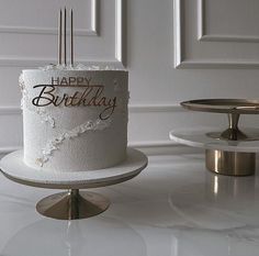 a white birthday cake sitting on top of a table