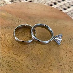 two wedding rings sitting on top of a wooden table