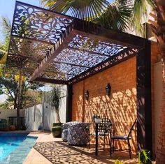 an outdoor patio with a table and chairs next to a pool