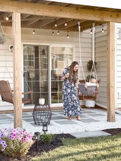 a woman is standing on the porch swing