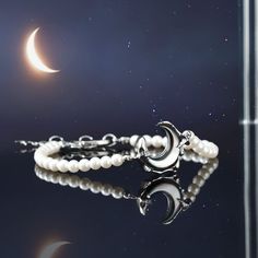 Catch a wave of gorgeousness with this Lunar Tide Pearl Bracelet! Made from pearls and set on a delicate chain of Platinum, this gorgeous accessory is sure to make you look out of this world! Add a hint of sparkle to any outfit and make a fashionable statement--the waves won't be able to resist! DETAILS Materials:   Platinum on Brass, Mother of Pearl Beads, Zircon Measurements: Length:  7.09 "(18cm)  + Extender: 1.18"(3cm) Weight:  6.9 g Elegant Moon Charm Bracelet, Elegant Adjustable Bracelet With Moon Charm, Elegant Moon Phase Bracelet As A Gift, Elegant Moon Phase Bracelets, Elegant Adjustable Crescent Jewelry, Elegant Adjustable Crescent Bracelet, Elegant Adjustable Crescent Shaped Jewelry, Elegant Moon Phase Bracelet As Gift, Elegant Moon Phase Bracelet For Gift