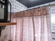 a bathroom with a mirror, shower curtain and shelf on the wall next to it