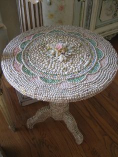 a table made out of beads with flowers on the top is shown in this image