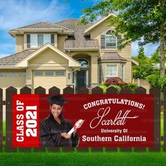 a graduation yard sign in front of a house with a graduate's photo on it