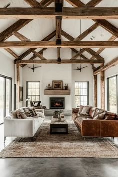 a living room filled with furniture and a fire place in the middle of an open floor plan