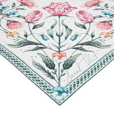 a white and blue floral design on the side of a table cloth, with pink flowers