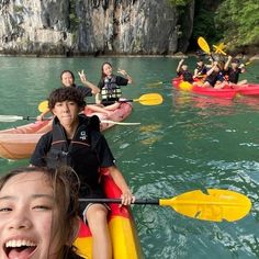 a group of people riding on top of kayaks