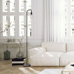 a living room with white furniture and large windows