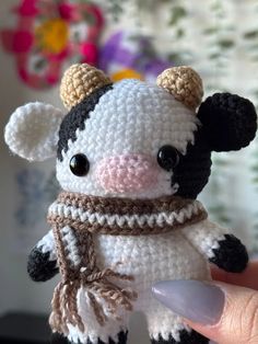 a small crocheted cow with a scarf around it's neck