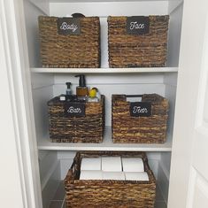 three wicker baskets with labels on them sit in the corner of a white closet