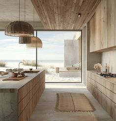 a large kitchen with wooden cabinets and an island countertop next to a window that looks out onto the beach