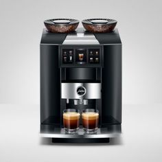 an espresso machine with two cups on the front and one in the back