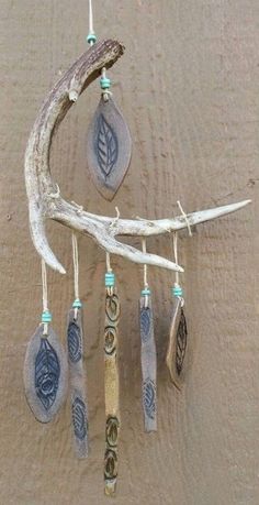 a wind chime hanging on the side of a wooden door with leaves and beads