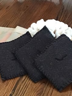 three pieces of cloth sitting on top of a wooden table next to a white napkin