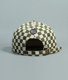 a green and white checkerboard hat with the word's logo on it