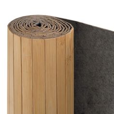 a roll of wood sitting on top of a piece of felt next to a wall