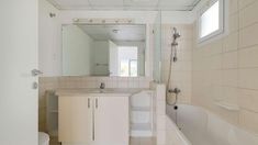 a bathroom with a sink, toilet and bathtub next to a mirror on the wall