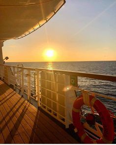 the sun is setting over the ocean on a boat