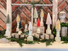 christmas decorations are displayed on a mantle in front of an old brick wall and window