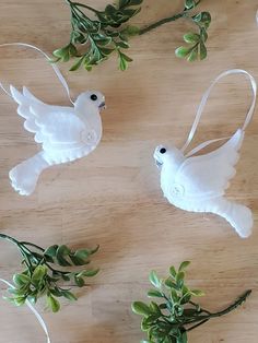 three white dove ornaments on a wooden table