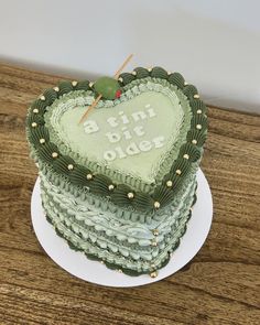 a green heart shaped cake on top of a wooden table