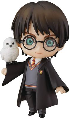 a harry potter figurine with an owl on his arm, holding it in one hand