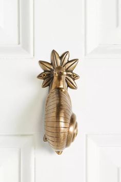 a gold pineapple shaped door handle on a white door