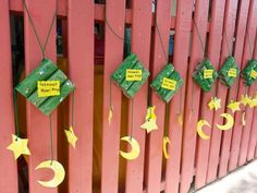 the fence is painted red and has green decorations hanging from it's sides with yellow stars