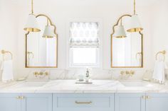 a bathroom with marble counter tops and blue cabinets