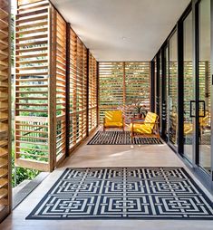 an outdoor area with wooden slats and black and white rug