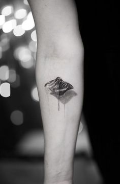 a black and white photo of a person's leg with a tattoo on it