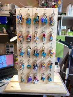 a wooden board with many different key chains hanging from it's sides on a table