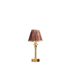 a gold lamp with a red shade on it's base and a white background